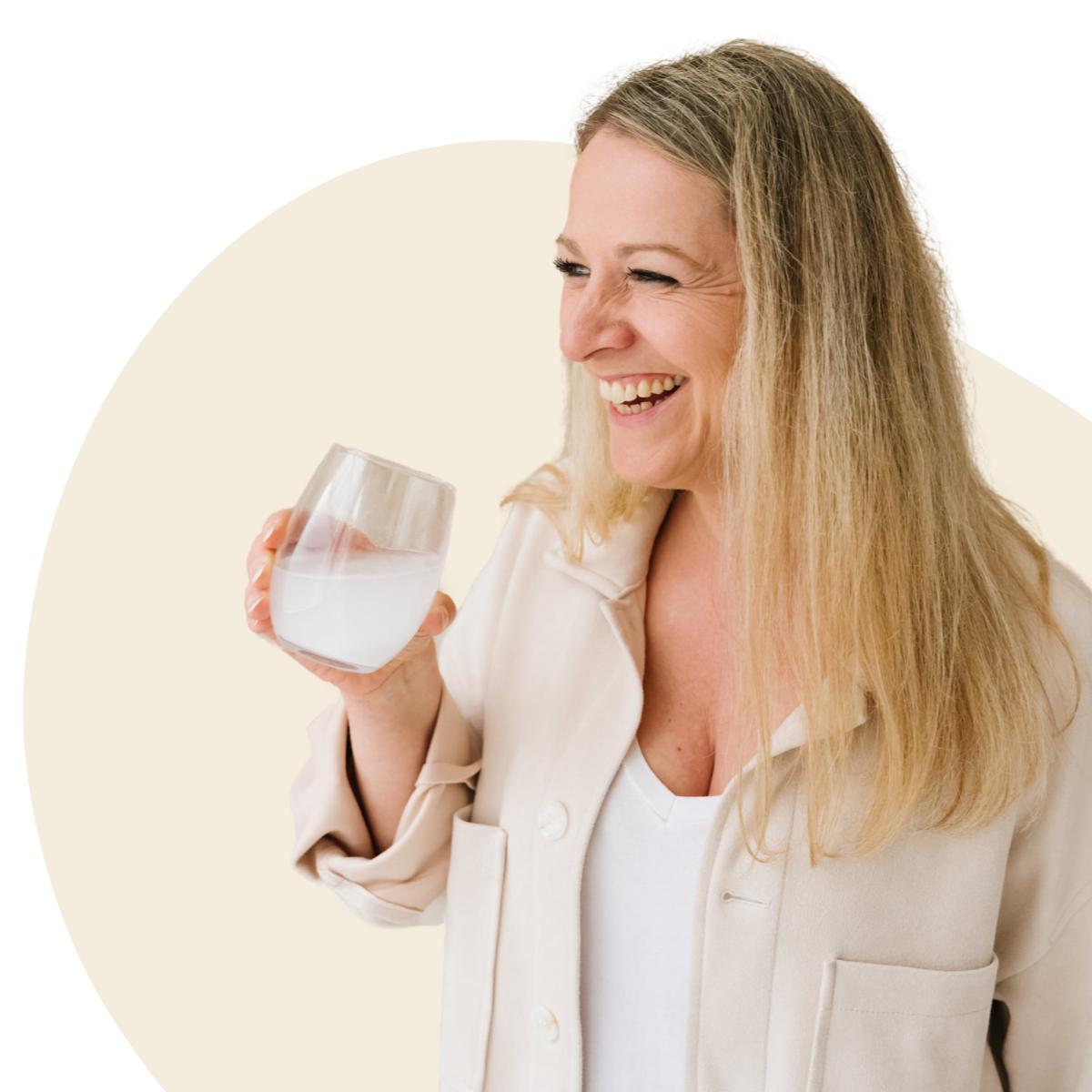 Femme souriante buvant un grand verre d'eau pour prendre ses compléments alimentaires