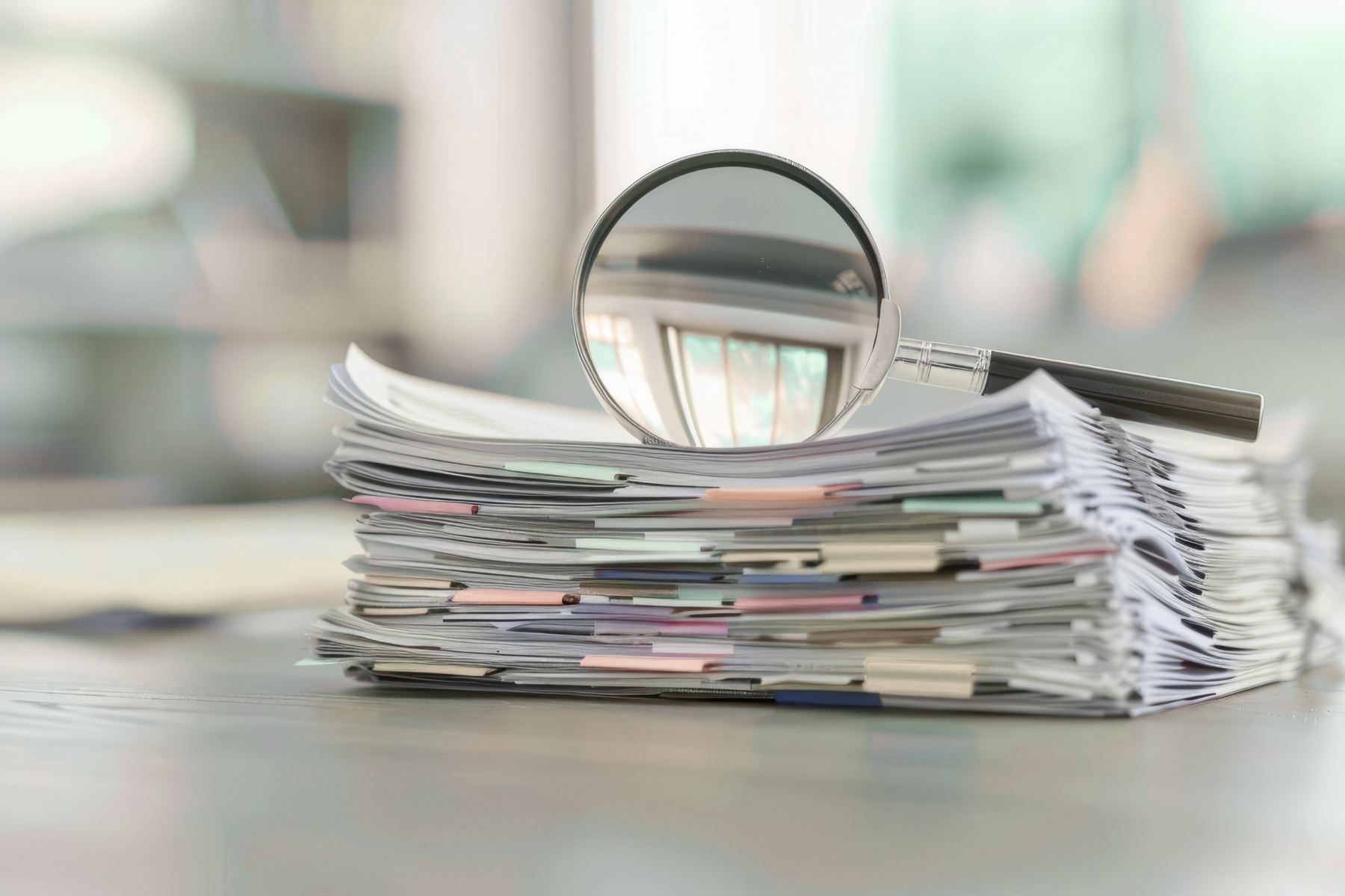 Loupe posée sur une pile de documents