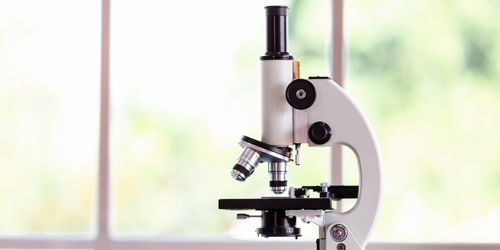 Microscope de laboratoire posé sur une table.