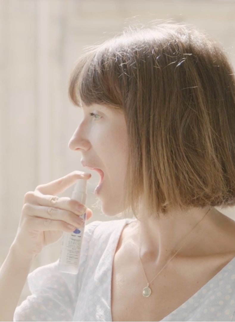 Une femme prend un spray de spray stress sous sa langue